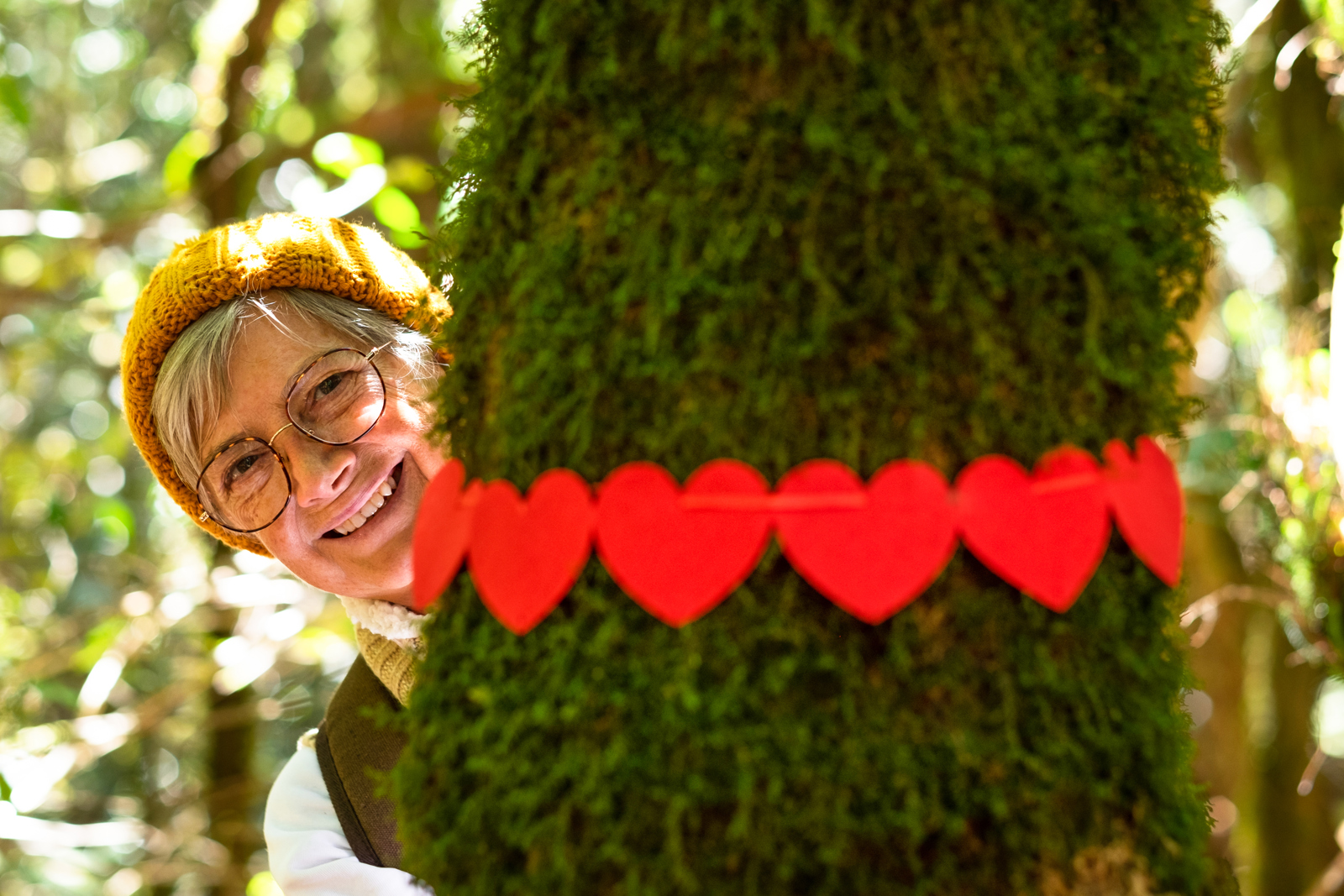 Smiling Elderly Woman Hugging A Moss Covered Tree 2024 11 02 23 10 05 Utc