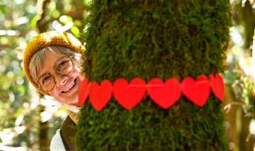 Smiling Elderly Woman Hugging A Moss Covered Tree 2024 11 02 23 10 05 Utc